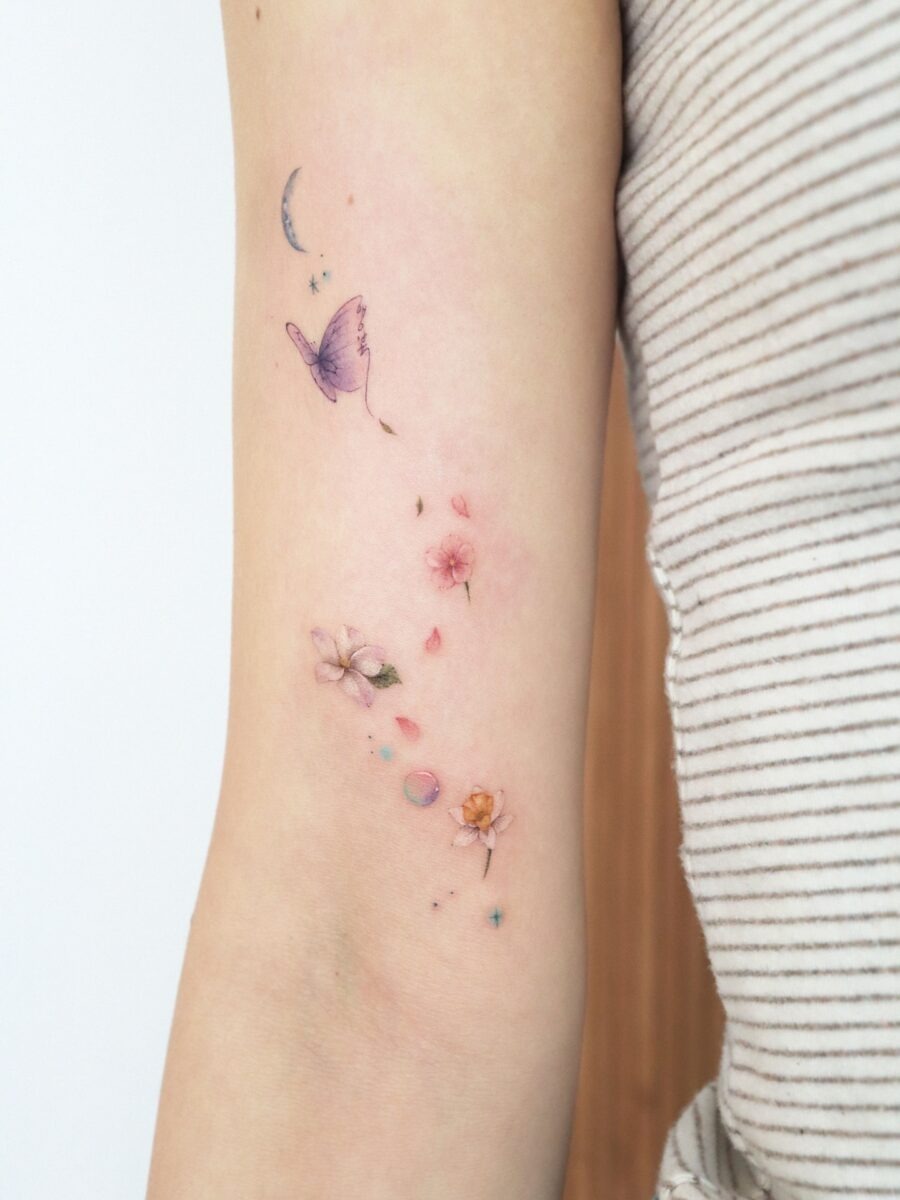 This tattoo features delicate flowers and a whimsical butterfly, blending nature's beauty with artistry.