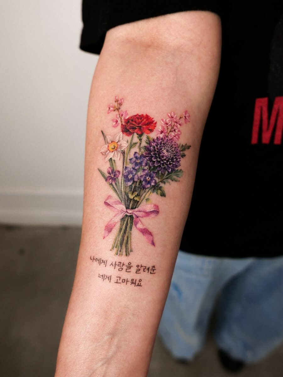 This tattoo features a beautifully arranged bouquet of colorful flowers, symbolizing love and growth.