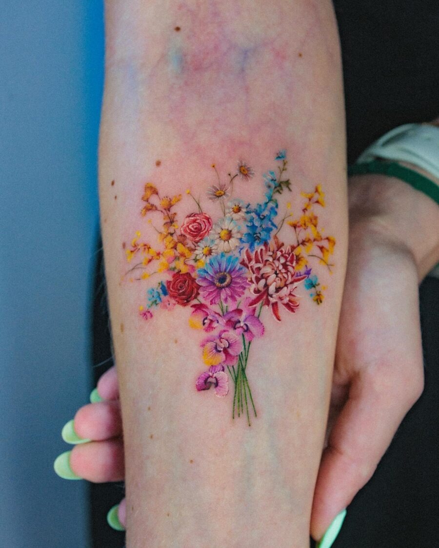 This stunning tattoo showcases a colorful bouquet of flowers, symbolizing various birth months.