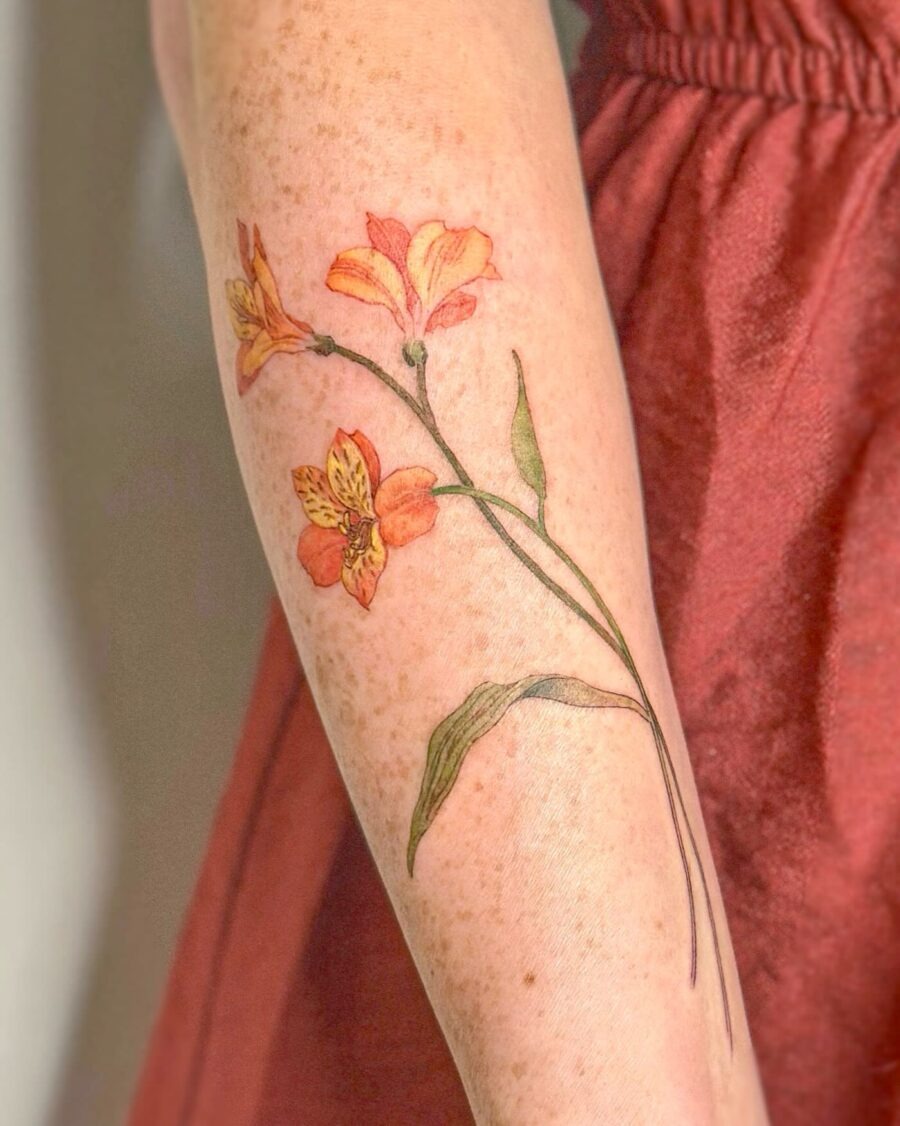 This tattoo showcases a stunning arrangement of colorful flowers, nestled elegantly on the forearm.