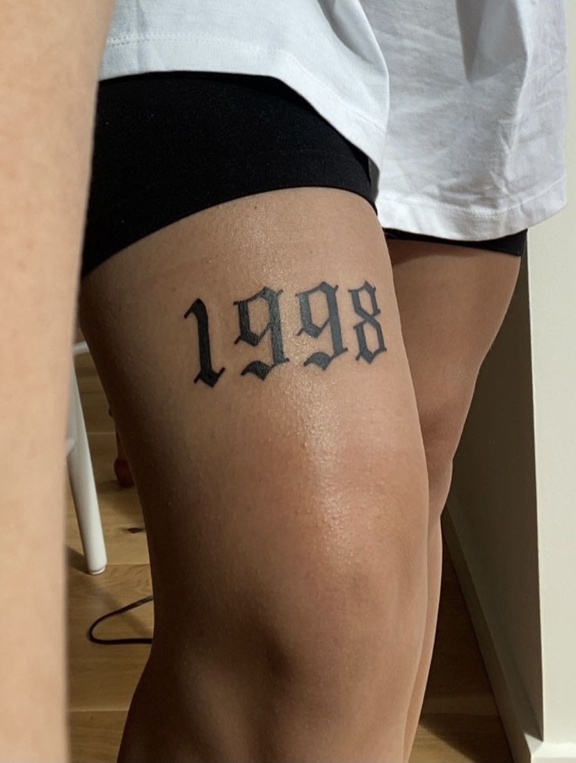 Bold 1998 Above-Knee Statement Tattoo Design