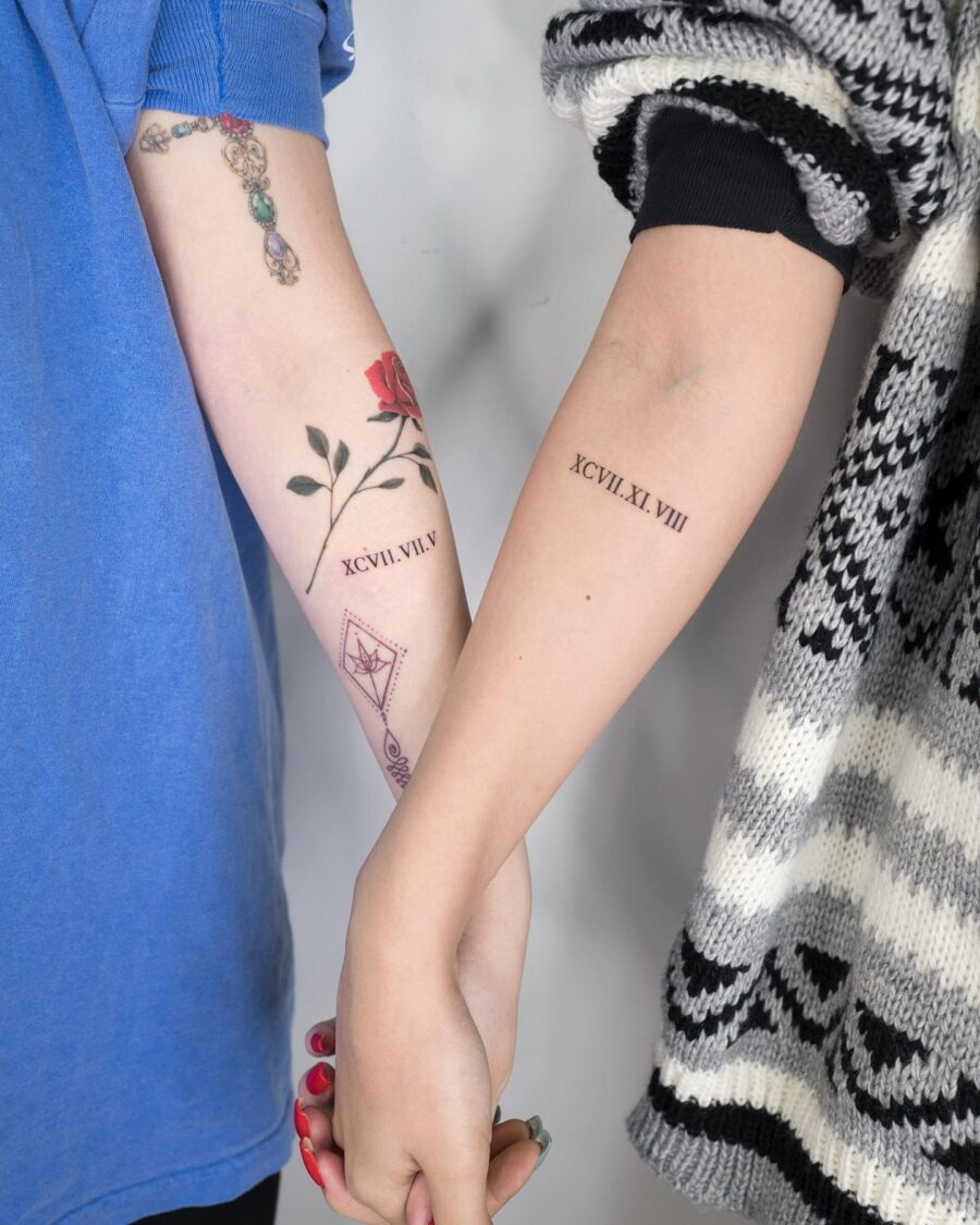 This image features two beautifully crafted birthday tattoos linked by the act of holding hands.