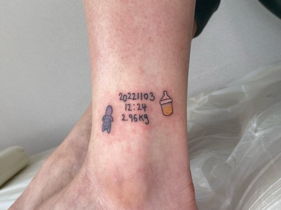 This tattoo features a charming design commemorating a birth.