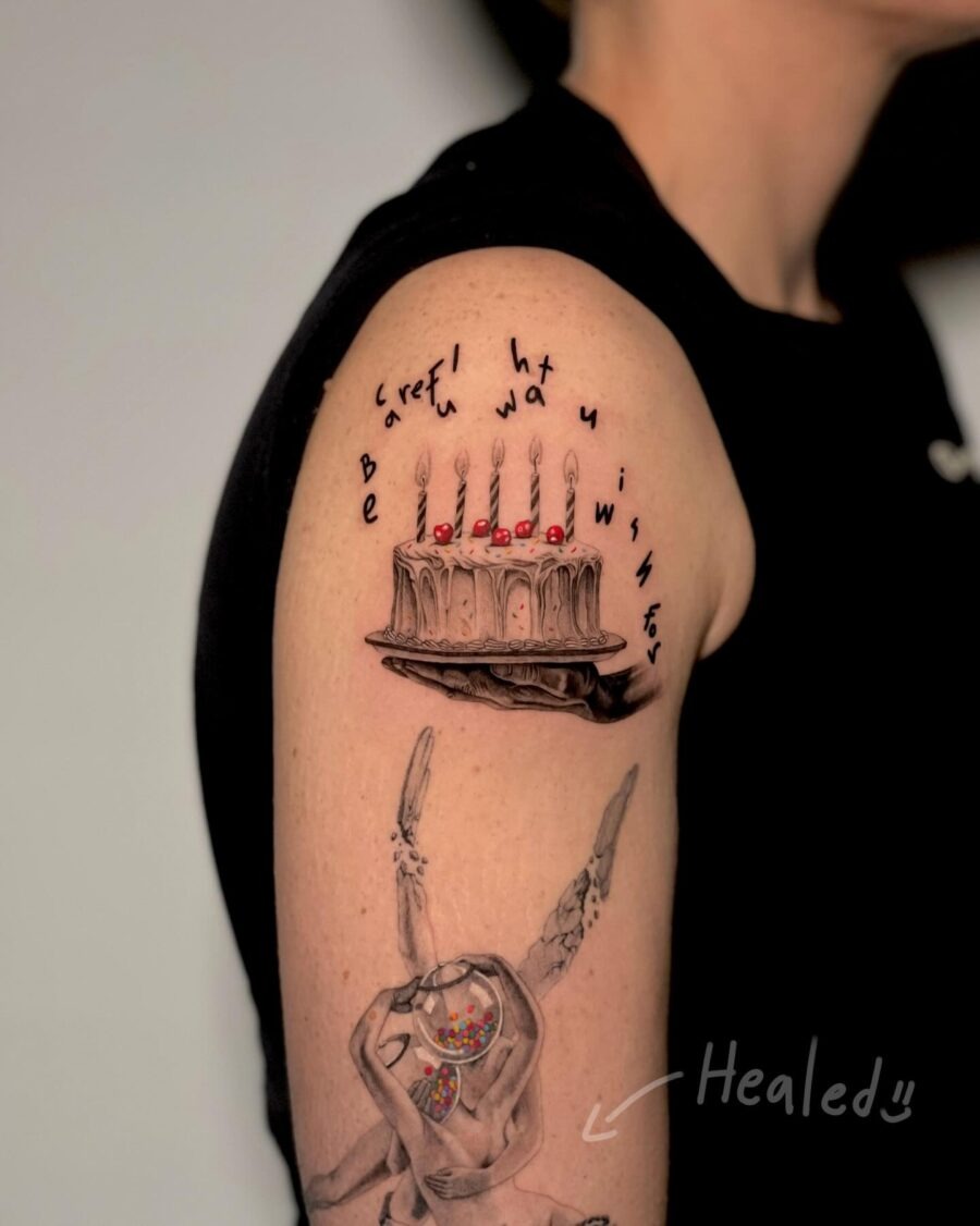 This tattoo features a beautifully detailed cake adorned with candles, symbolizing celebration and wishes.