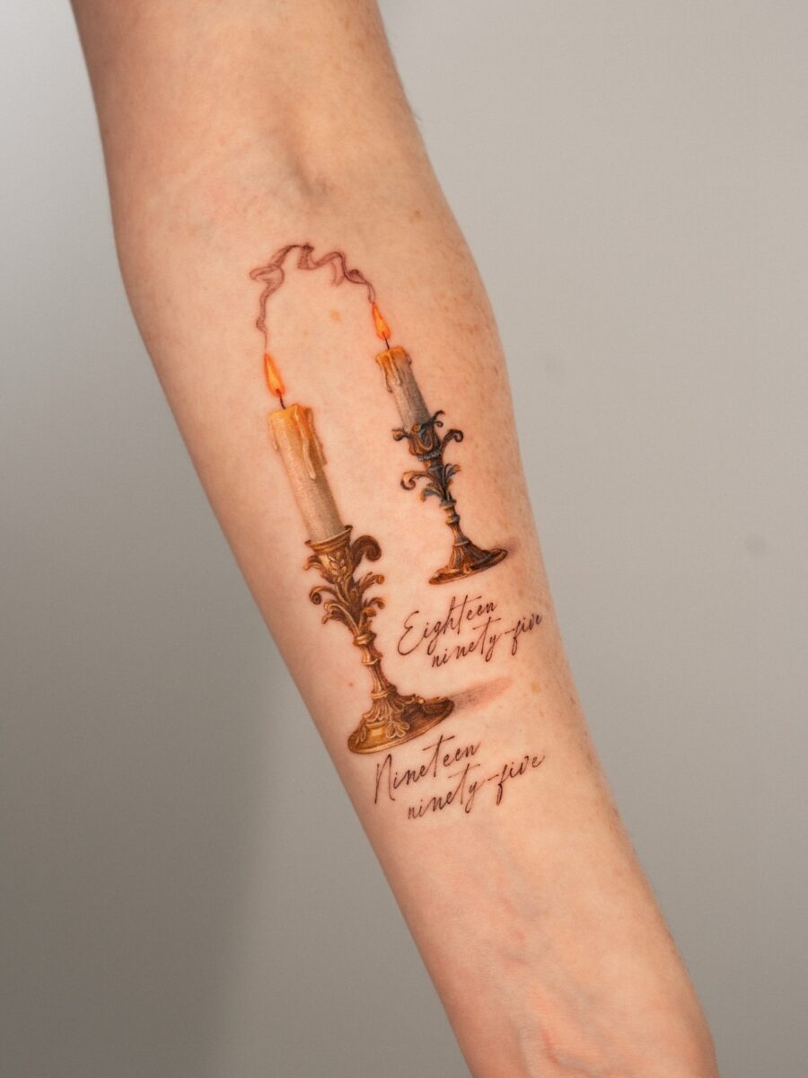 This tattoo features two beautifully designed candles, symbolizing the celebration of life and birthdays.