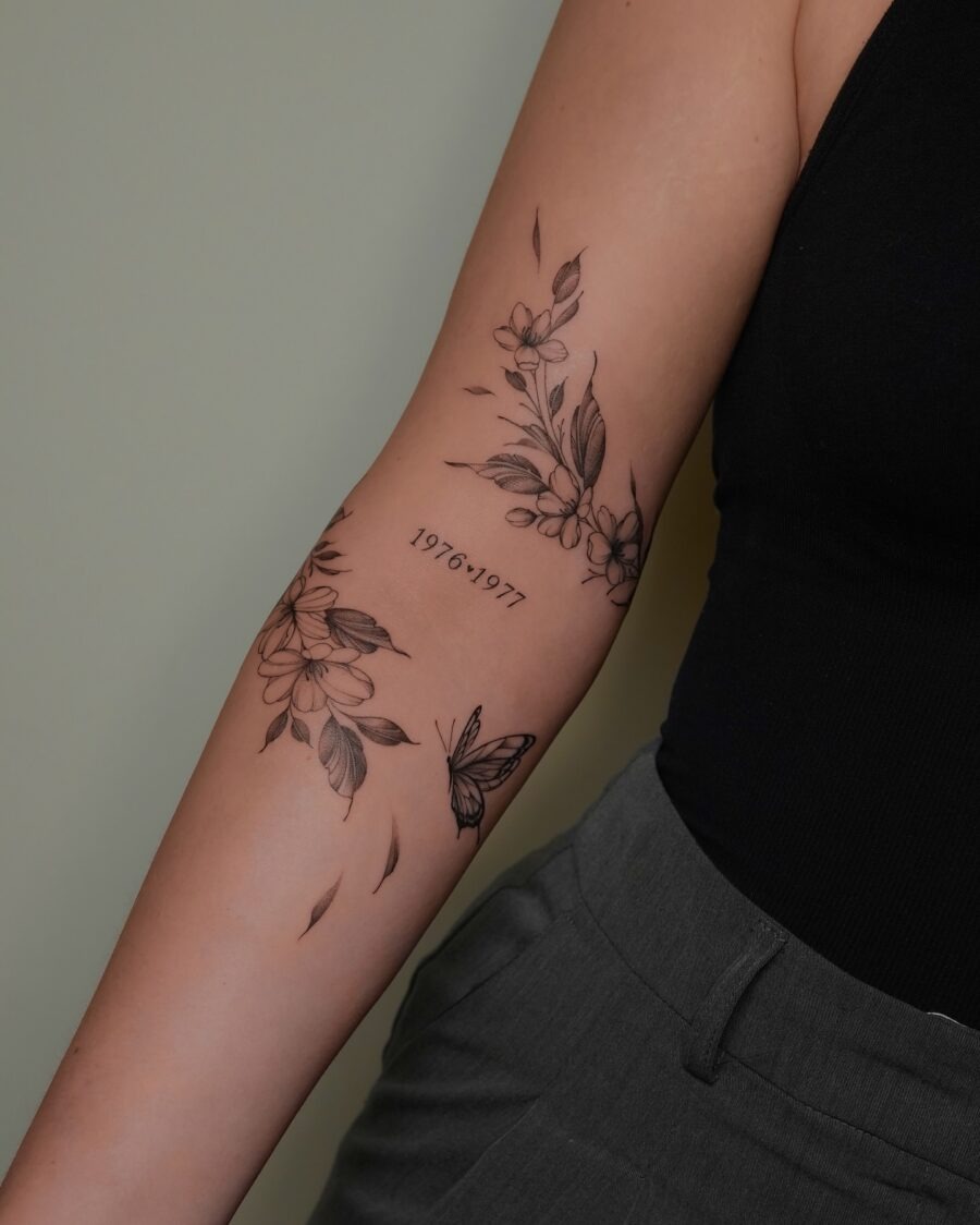 This tattoo features beautifully intricate floral designs with a delicate butterfly, expressing a sense of nature and elegance.