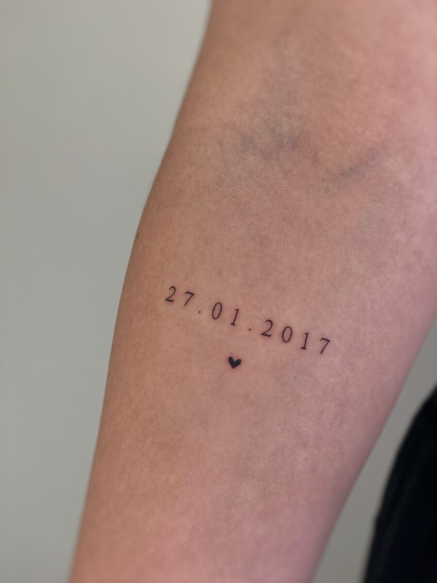 This elegant tattoo features a significant date, beautifully inked in a minimalist style.