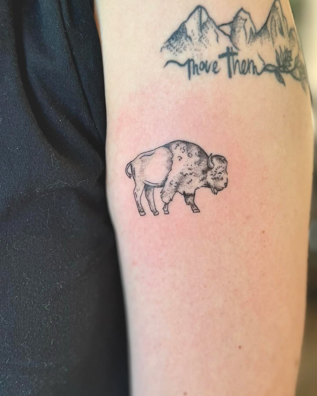This bison tattoo features a sleek, minimalist design in black ink.