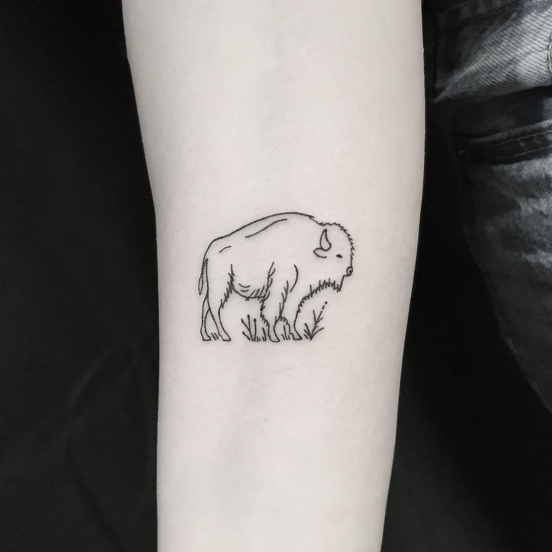 This minimalist bison tattoo showcases the majestic animal in delicate line art.