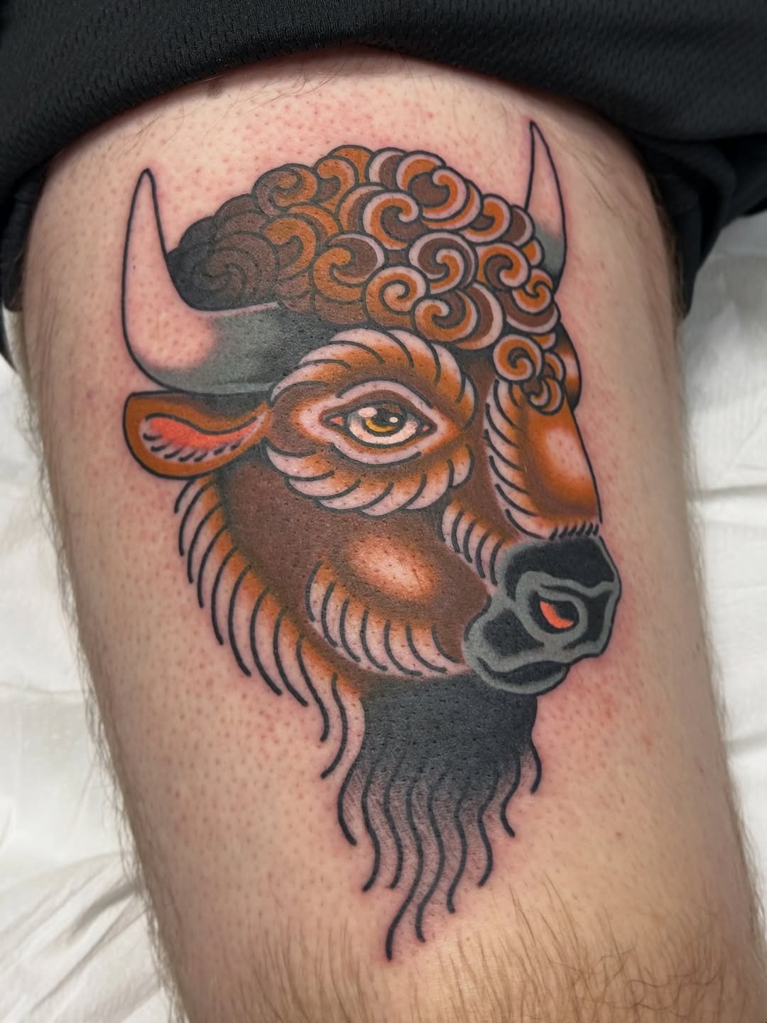 This bison tattoo combines colors with a unique design.