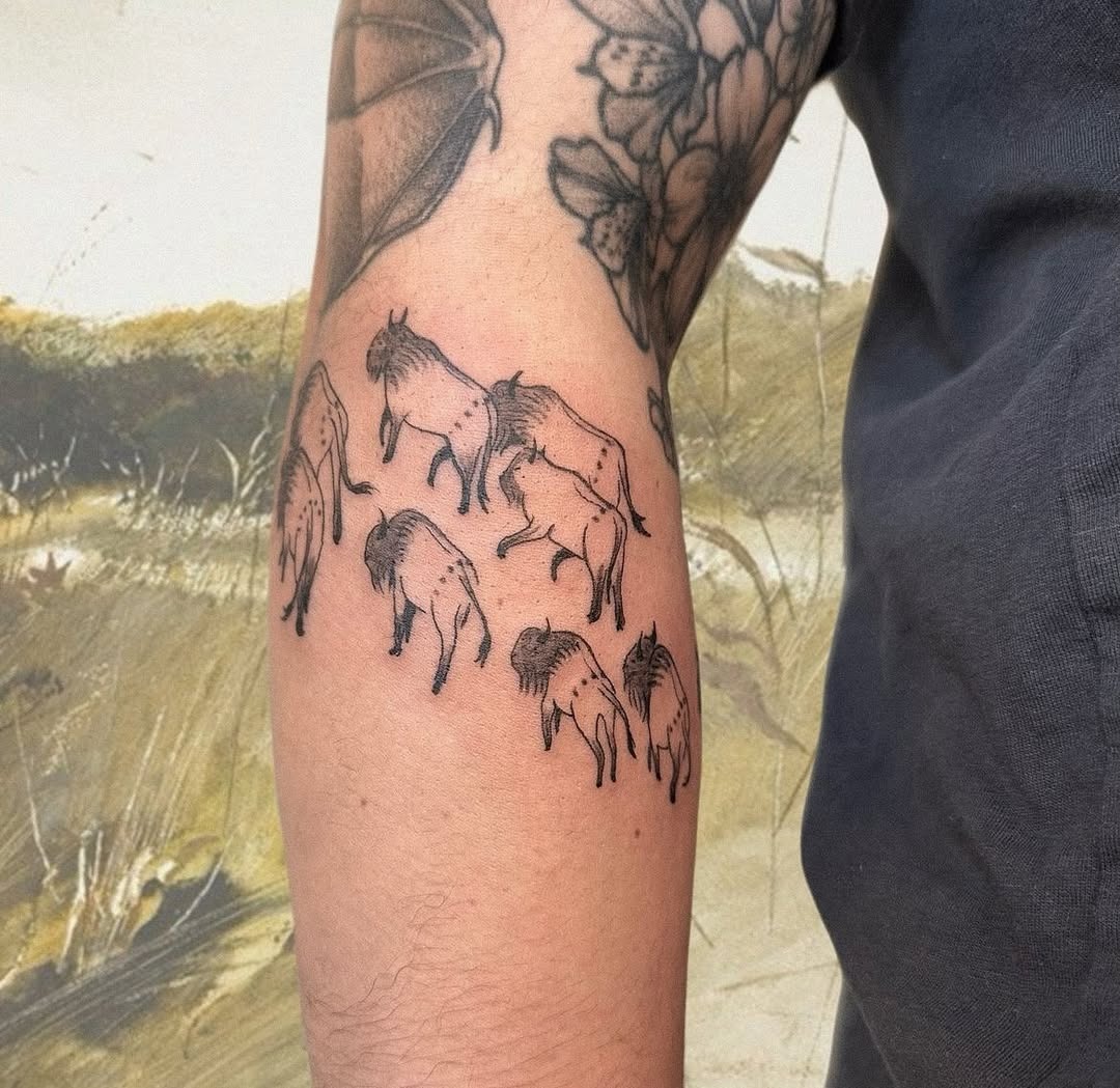 This tattoo features a series of bison in delicate line art, perfectly capturing their majestic essence.