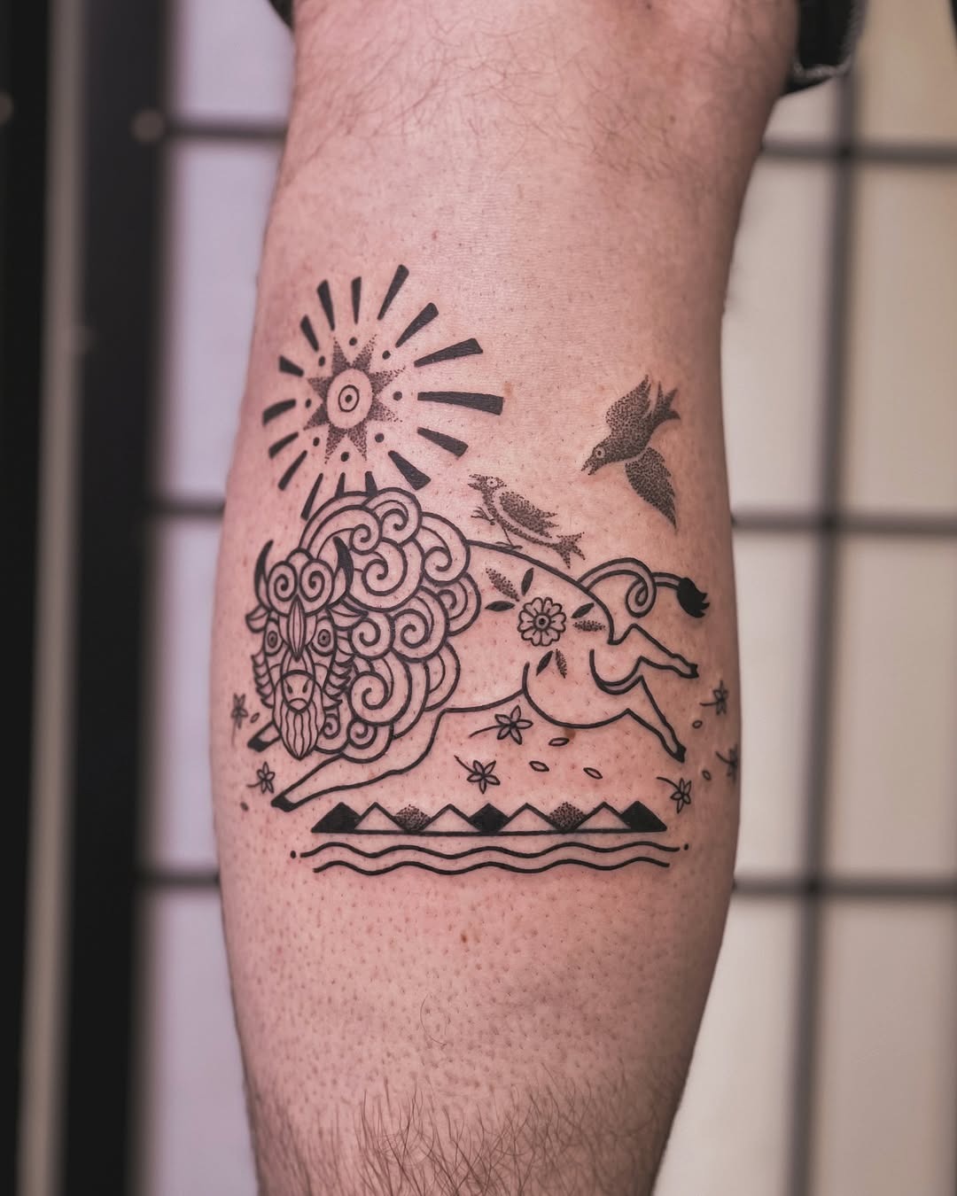 This tattoo showcases a bison amidst swirling patterns and natural elements.