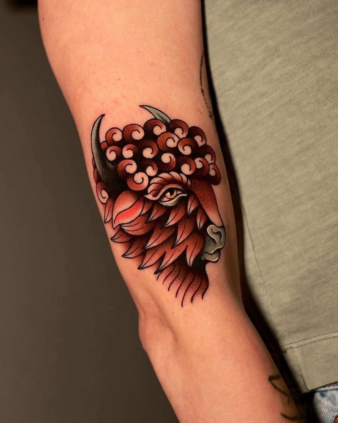 This bison tattoo showcases bold colors and intricate lines, blending natural beauty with artistic flair.