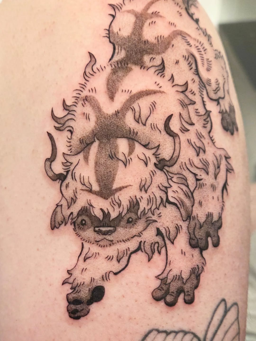 This tattoo features a whimsical interpretation of a bison, adorned with playful lines and furry textures.