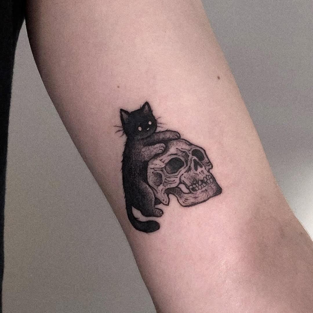 Charming black cat perched on a skull Tattoo Design