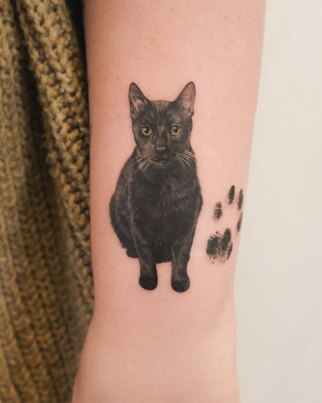 Realistic black cat with paw prints design Tattoo Design