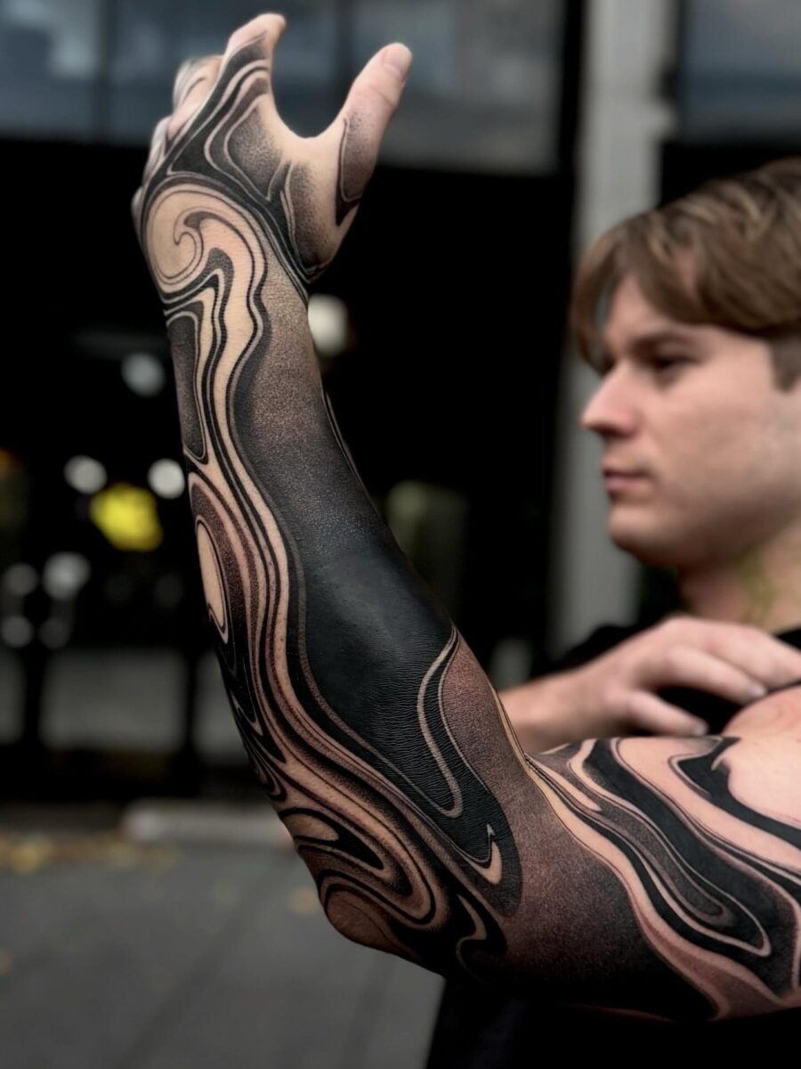 The design centers on dynamically swirling black sleeve imagery that reads clearly at a glance.