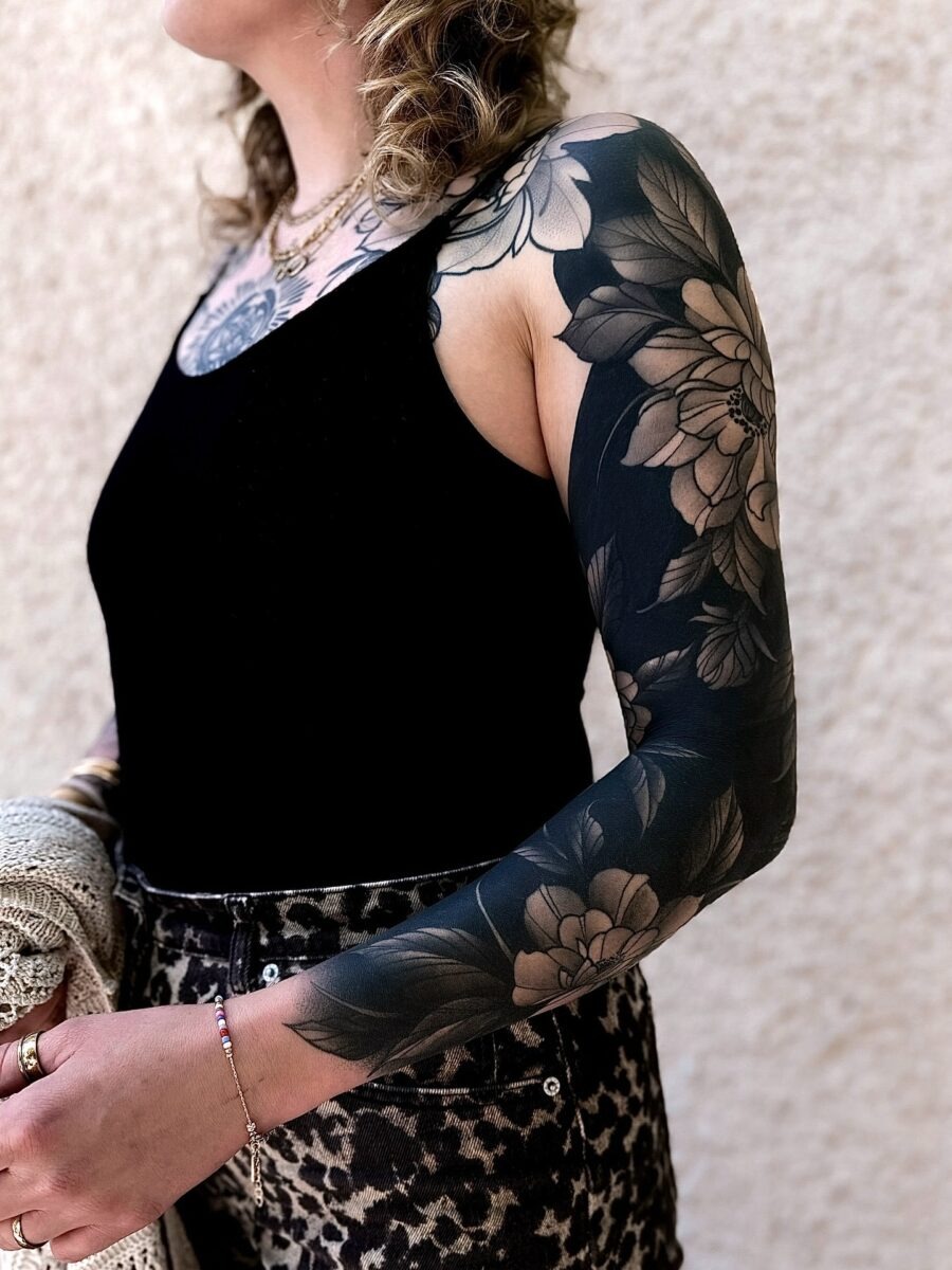 This striking tattoo features stunning floral patterns that wrap around both arms.