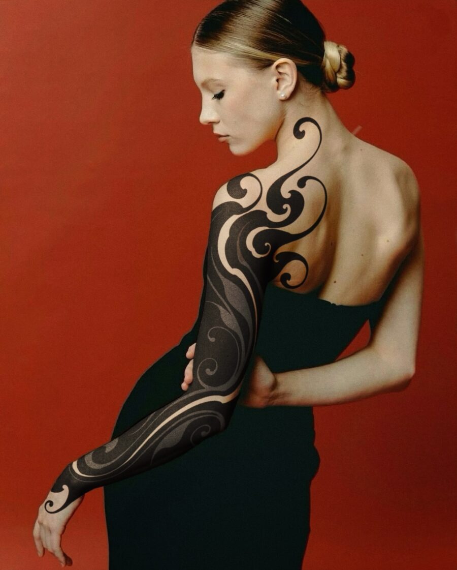 This striking black sleeve tattoo showcases elegant swirling designs that wrap around the arm.