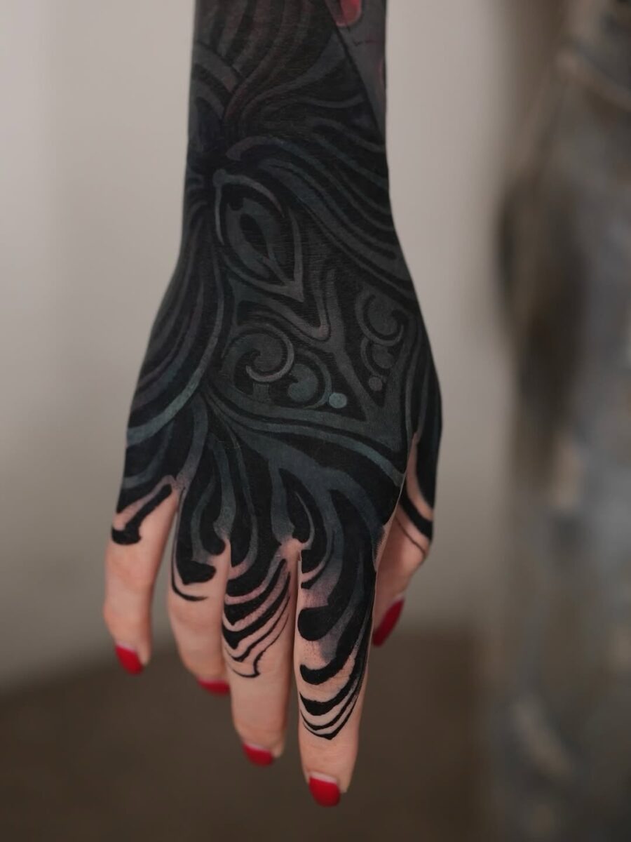 This image showcases a captivating black sleeve tattoo elegantly wrapped around a hand.