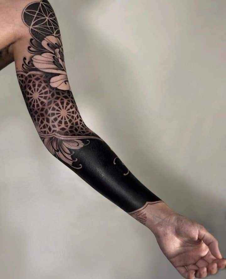 Floral Accents on Blackout Forearm Tattoo Design