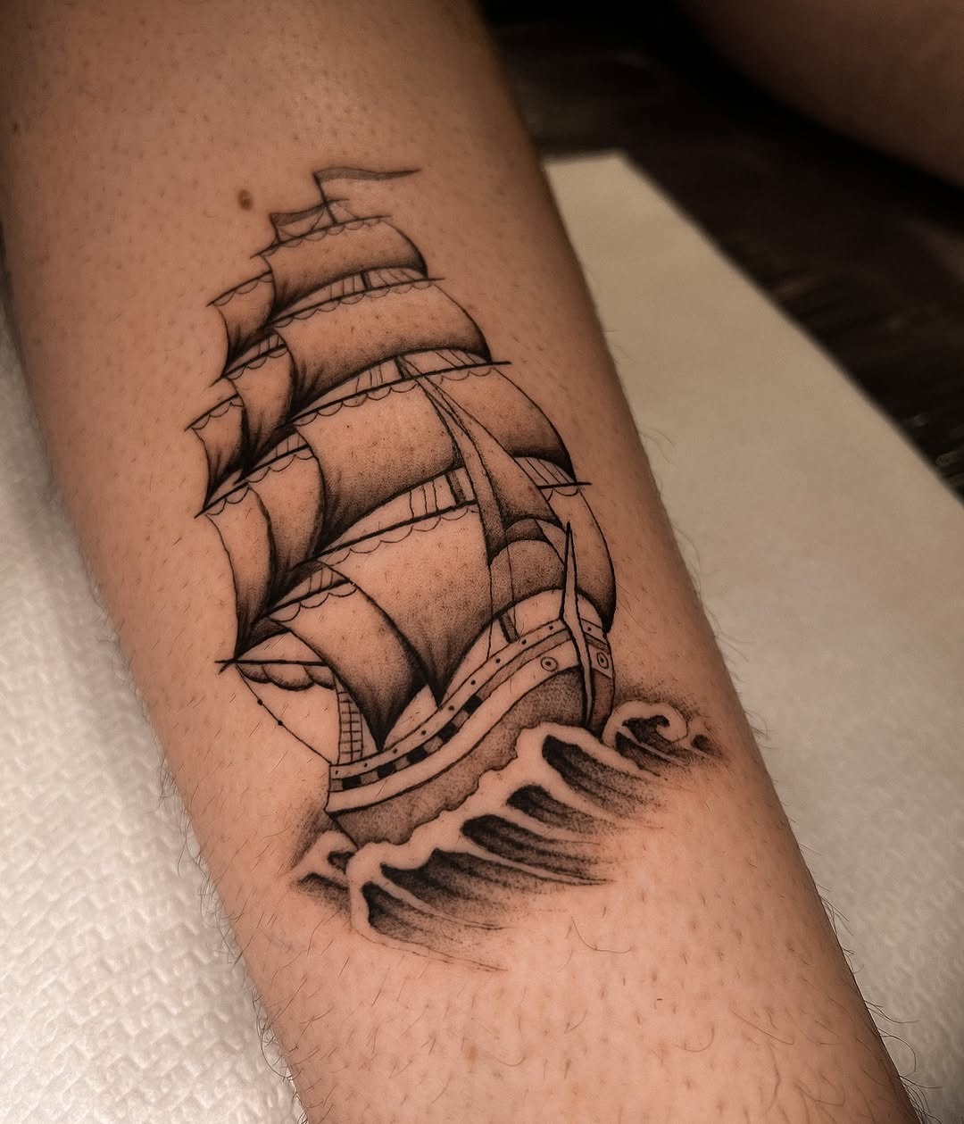 Elegant sailing ship tattoo with wave accents Tattoo Design