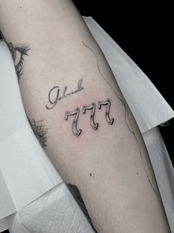 Delicate Shaded 777 Forearm Tattoo, a tattoo design rendered in clean detailed linework.