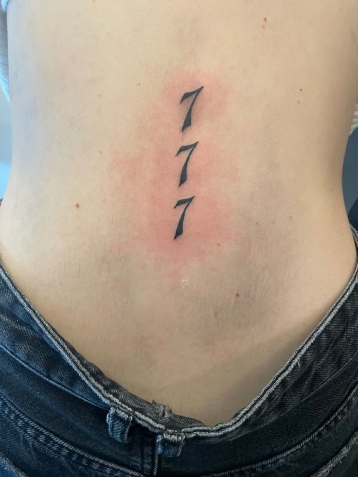 Lower Back Vertical 777, a tattoo design rendered in clean detailed linework.