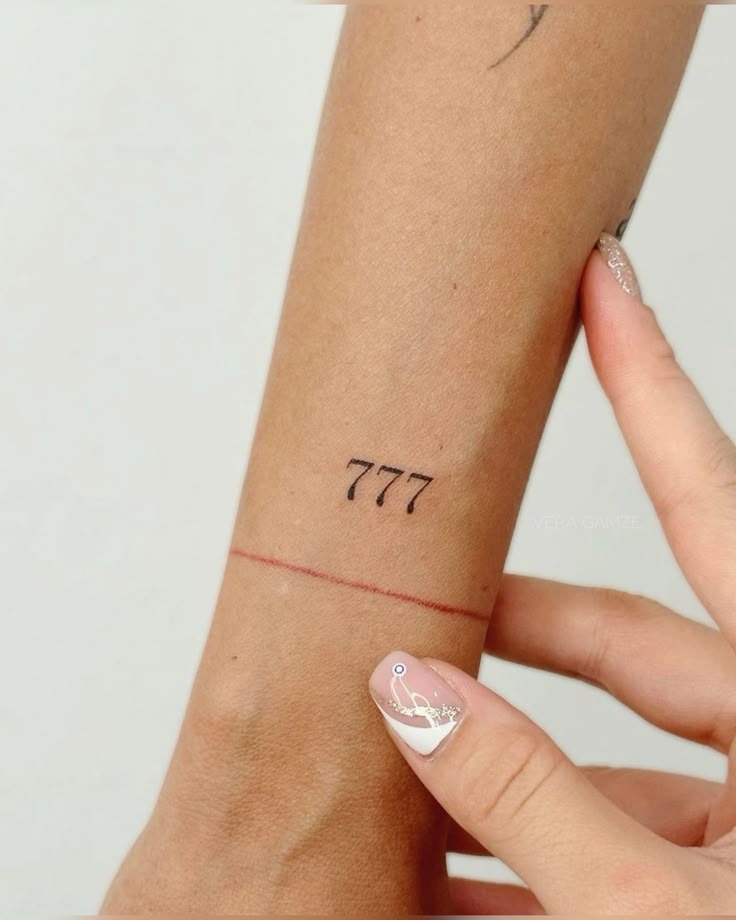 Tiny Wrist 777 Tattoo, a tattoo design rendered in clean detailed linework for the arm.