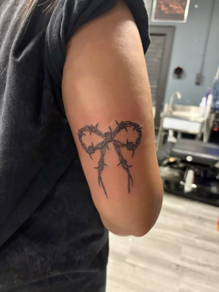 Barbed Wire Bow on Back Arm Tattoo Design