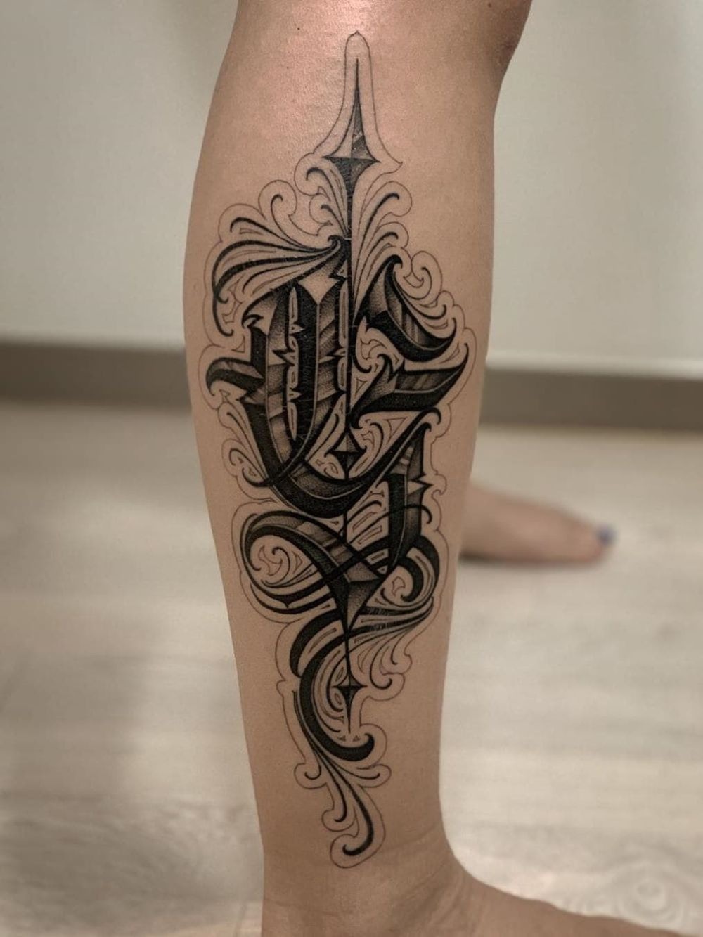 Ornamental Script Dagger Calf Statement Tattoo Design