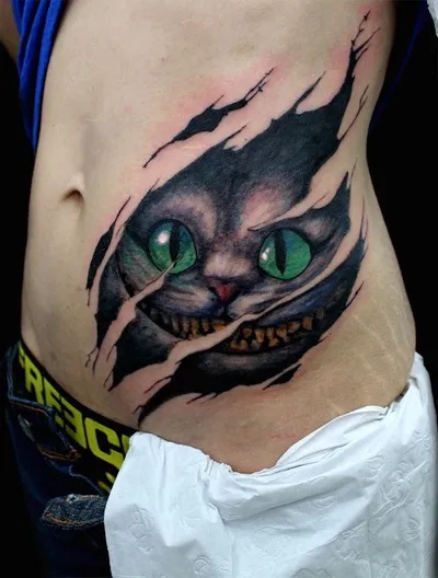 For those seeking a more dramatic representation, this 3D effect tattoo brings the Cheshire Cat to life as though it's ripping through the skin.