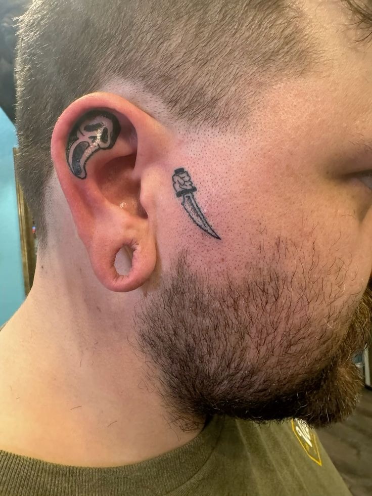 Micro Ghostface in the Ear Tattoo Design