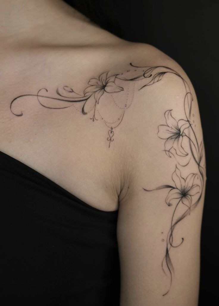 Delicate Fine Line Lily Shoulder Tattoo, a tattoo design rendered in clean detailed linework for the upper arm.