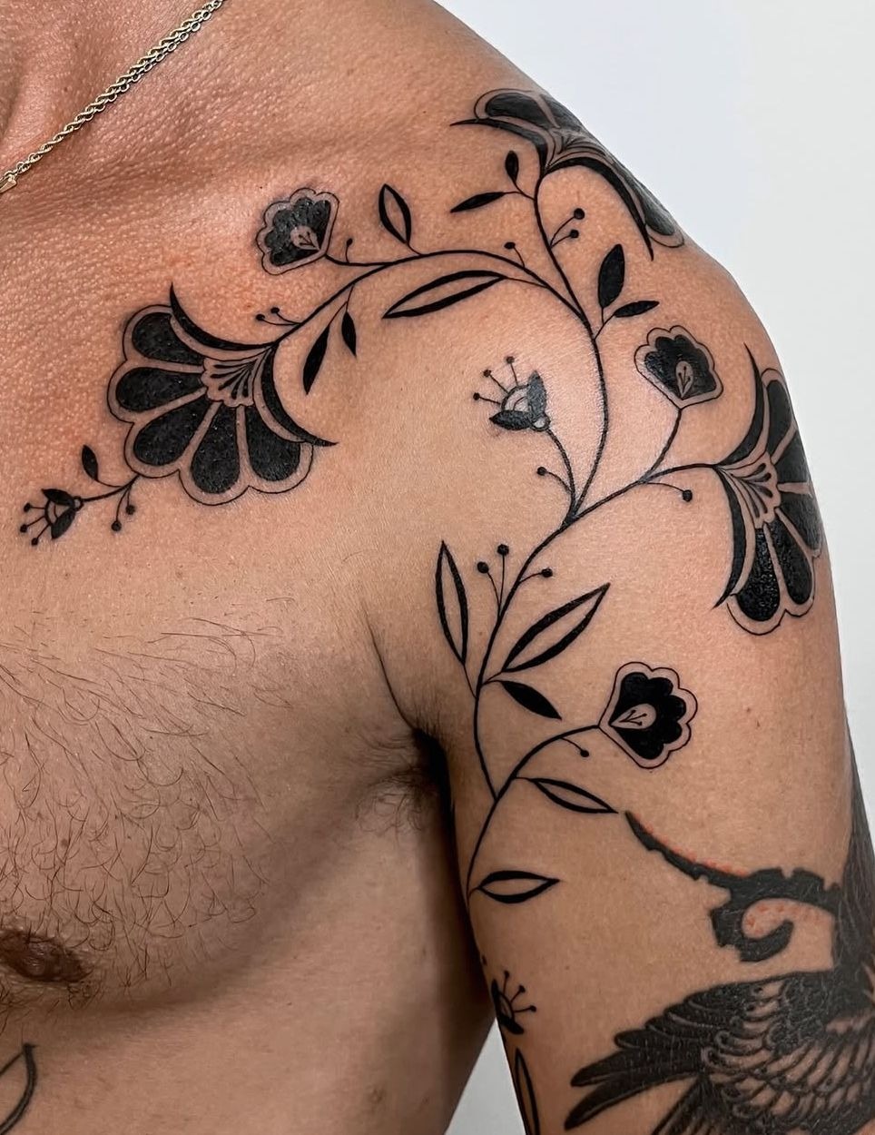 Flowing Black Floral Vine Shoulder Tattoo, a tattoo design rendered in geometric for the upper arm.