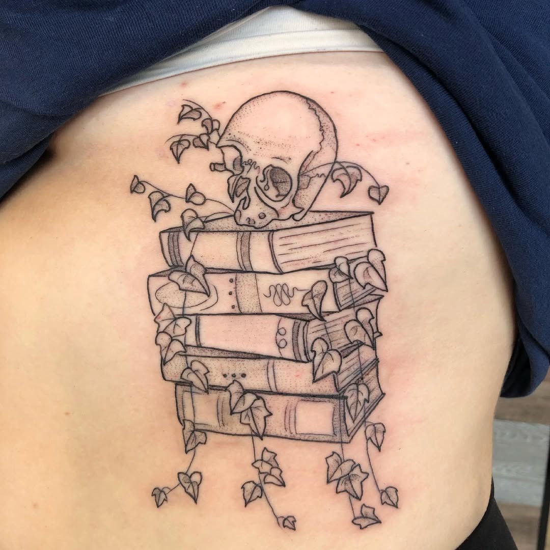 This tattoo features a skull nestled among stacked books, with ivy vines elegantly weaving between them.