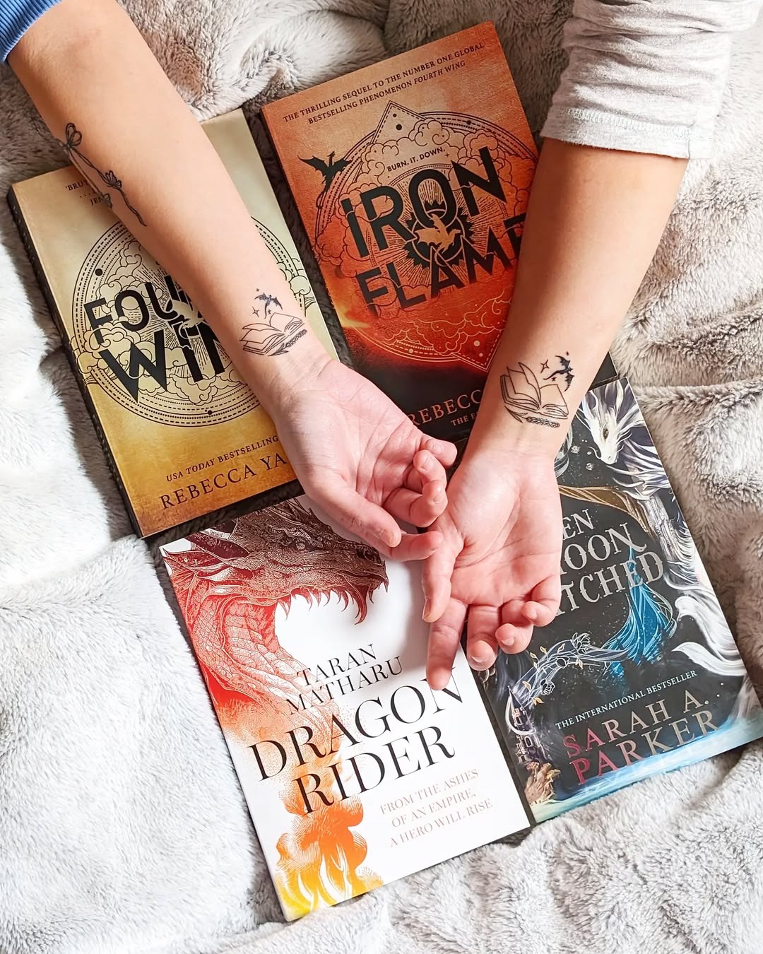 This image showcases beautifully crafted book-themed tattoos on each arm, adorned with literary motifs.