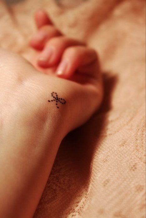 Simple bow tattoo design on a wrist Tattoo Design