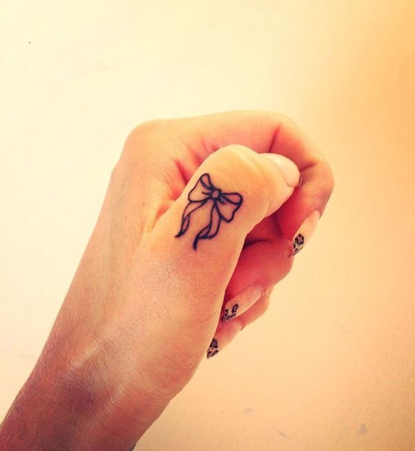 Tiny tattoo of a bow on a thumb Tattoo Design