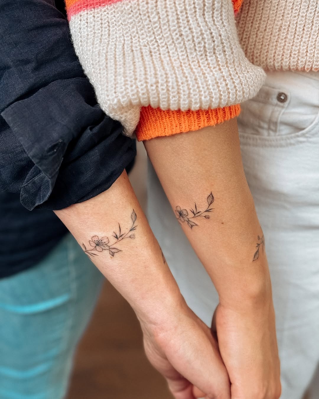 This image showcases two delicate bracelet tattoos adorned with floral elements.