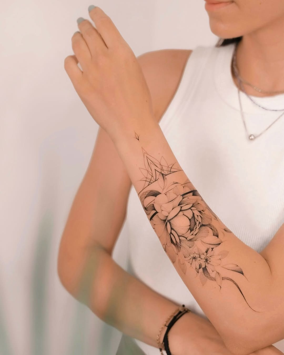 This stunning tattoo features intricate floral designs wrapping gracefully around the arm.