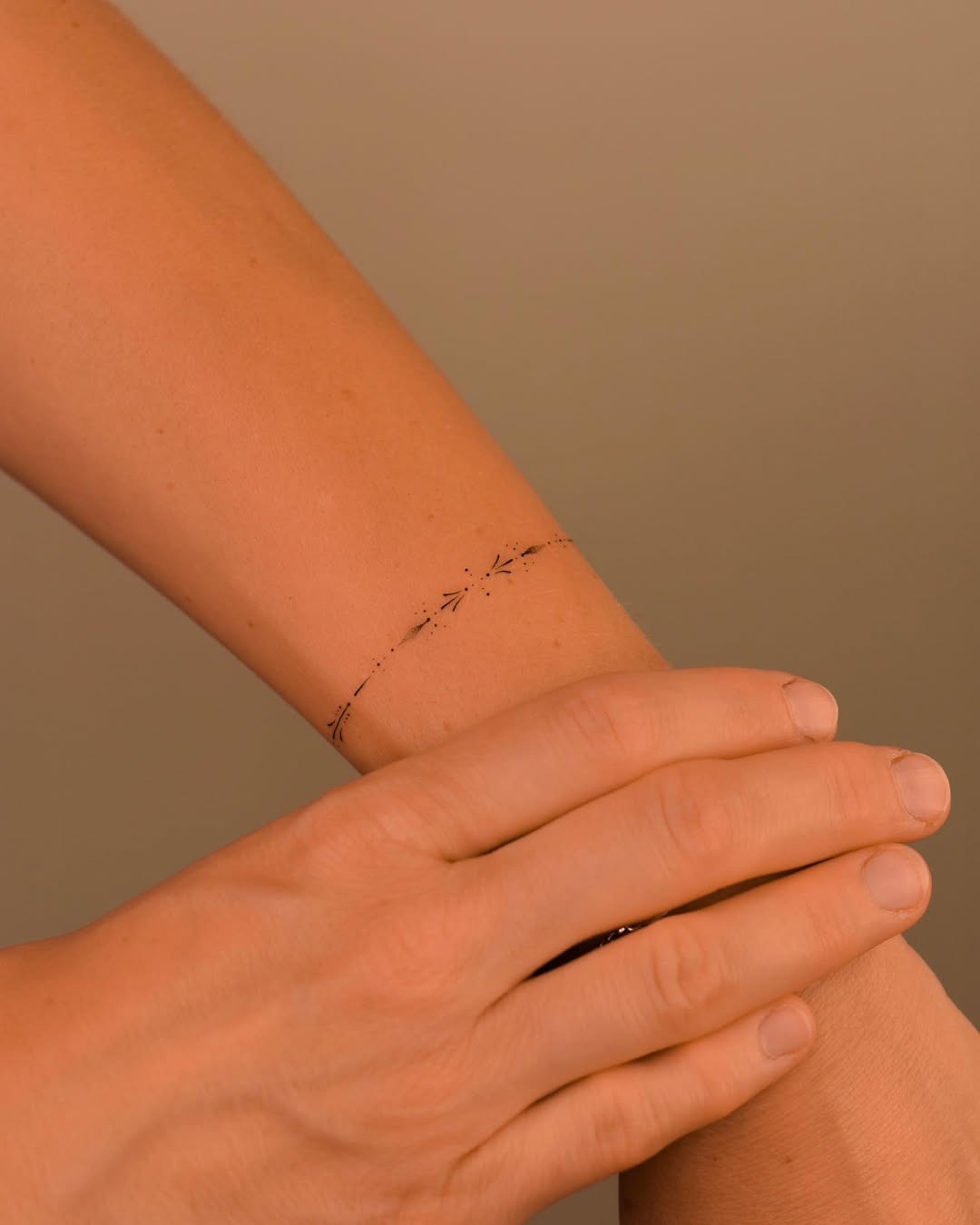 This tattoo features a delicate floral design that wraps around the wrist, giving an elegant and understated vibe.