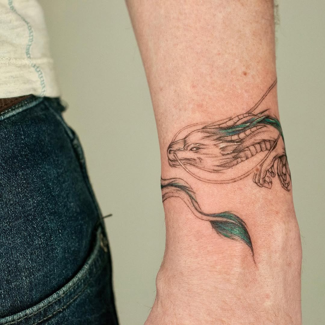 This stunning tattoo showcases a dragon elegantly wrapped around the wrist, complemented by flowing waves.