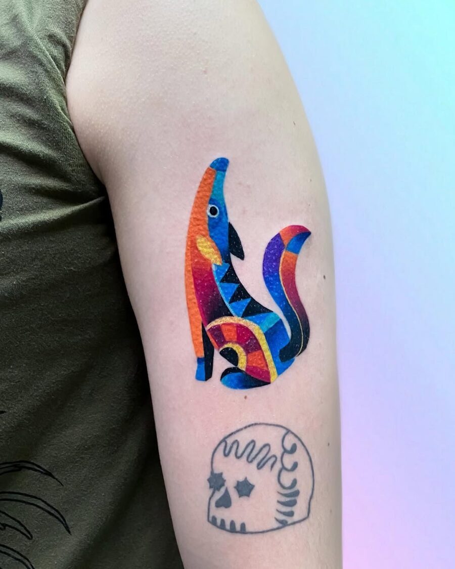 This bright color tattoo features a playful cat design, infused with vivid hues and dynamic patterns.