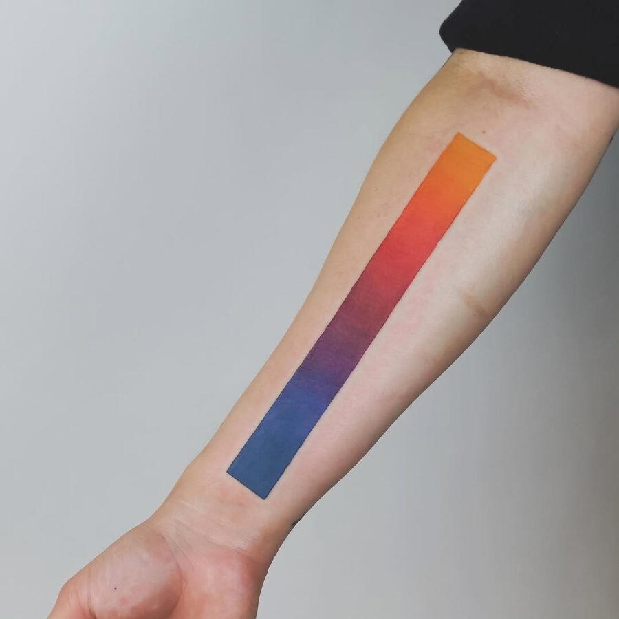 This tattoo features a striking gradient of colors, transitioning smoothly from bright orange to deep blue.
