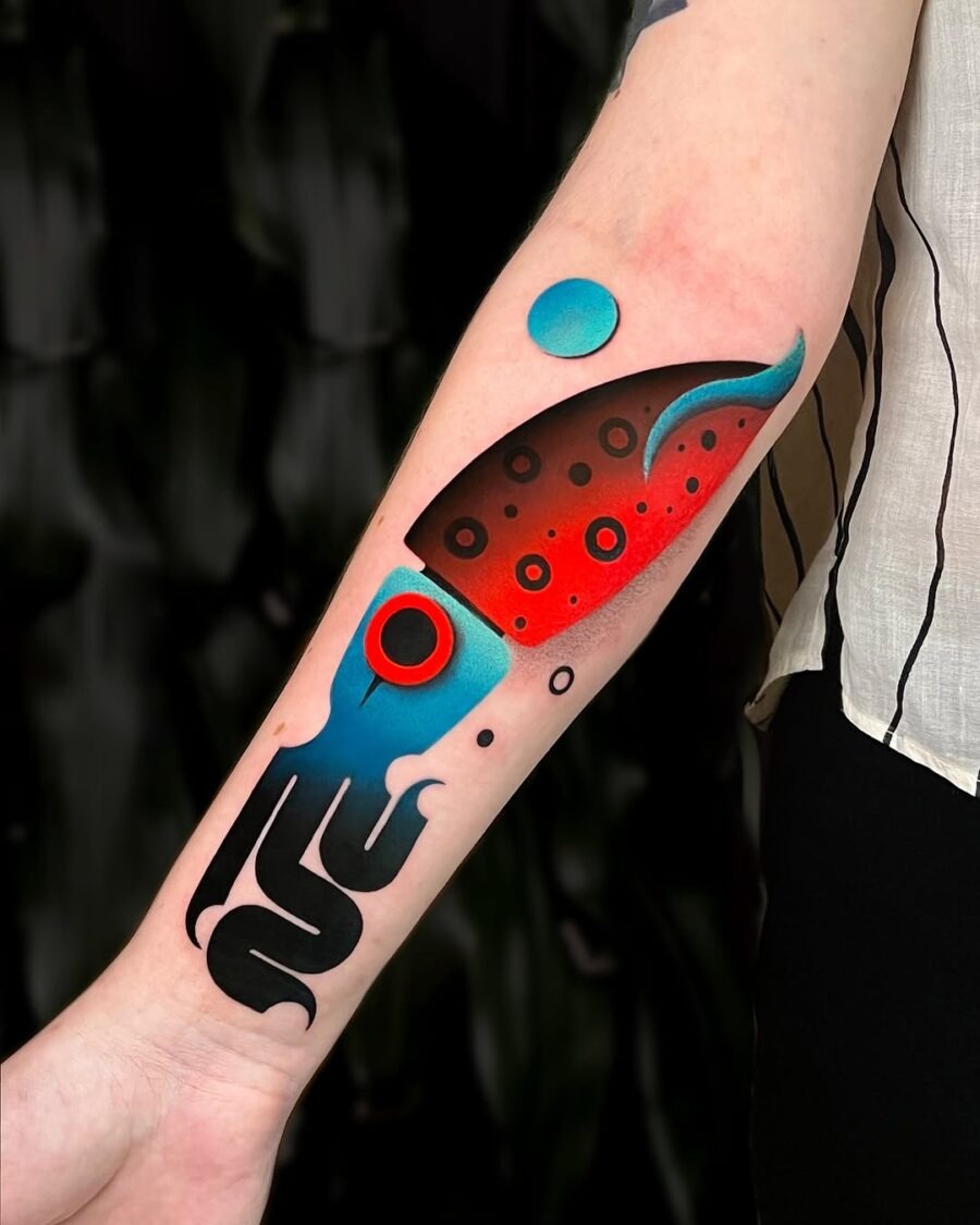 This squid tattoo showcases a mix of bright colors like red and blue, creating a striking contrast against a dark background.