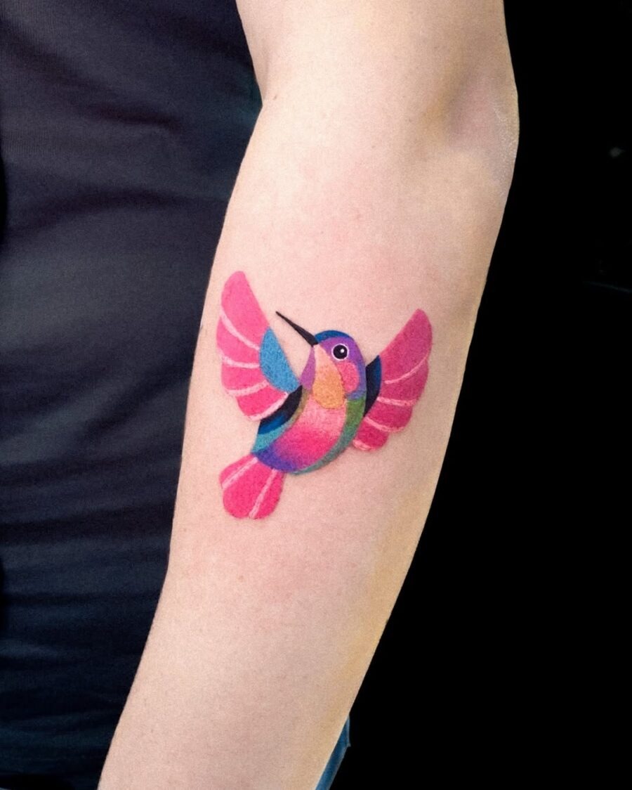 This tattoo captures a hummingbird in flight, showing bright colors that create a playful and lively vibe.