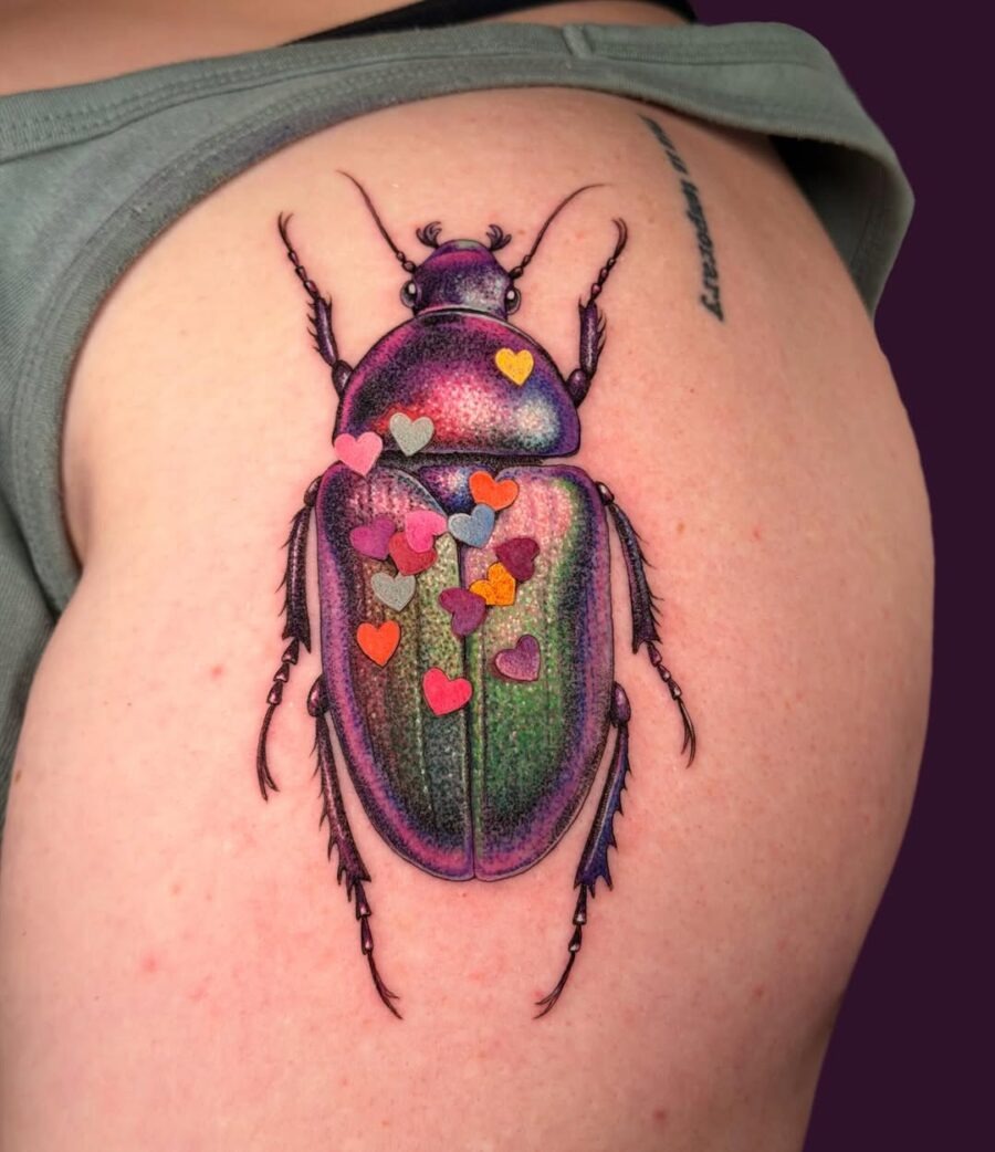 This beetle tattoo radiates with striking colors and playful heart embellishments.
