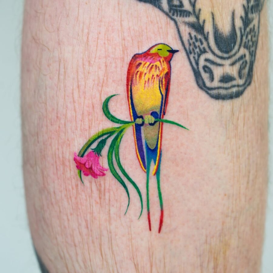 This tattoo features a striking toucan with bright, vivid colors and whimsical details.