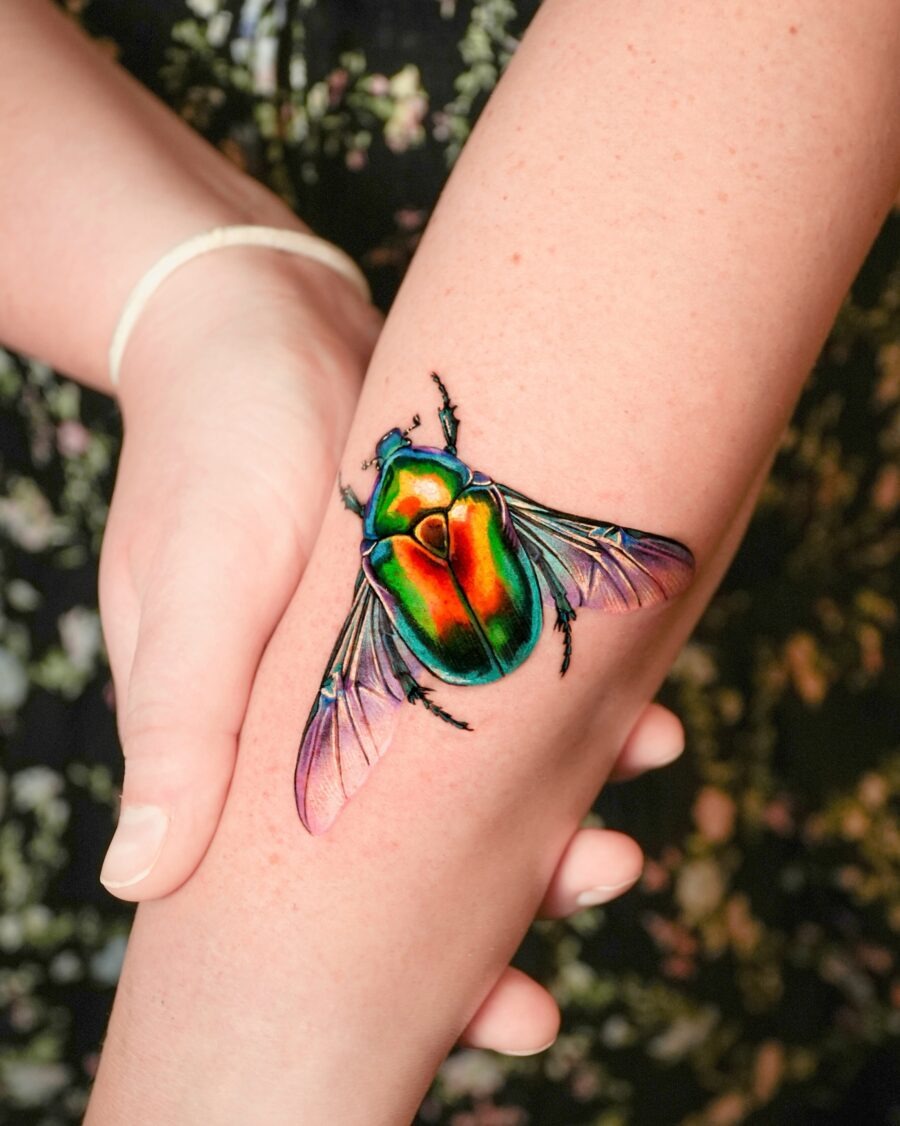 This stunning beetle tattoo showcases a brilliant array of colors, bringing life to the skin.